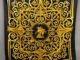 a black and gold scarf hanging on a wall