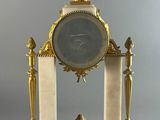 a clock that is sitting on top of a stand