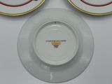 two white plates with gold rims on a white table
