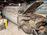 une vieille voiture qui prend la poussière dans un garage