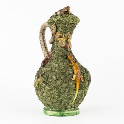 une image représentant un vase vert sur lequel est posé un lézard