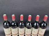six bottles of red wine lined up in a row