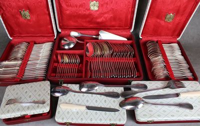 beaucoup d'argenterie dans un coffret rouge posé sur une table