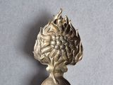 an image of a silver spoon with a flower on it