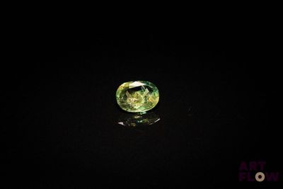 a close up of a green diamond on a black surface
