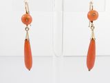 an image of a pair of earrings with orange beads hanging from them