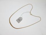gros plan sur un collier en or portant une étiquette