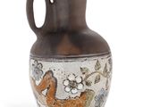 un vase avec un oiseau posé sur une table