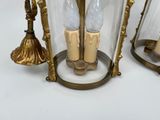 two candles that are sitting inside of a glass lantern