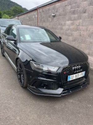 the black audi rs4 is parked in front of a brick wall