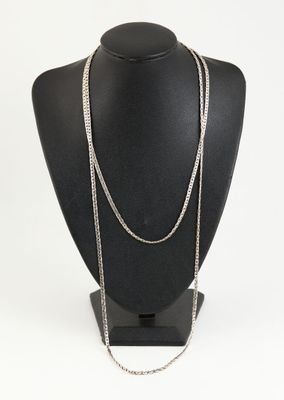 a black mannequin with a silver chain on it