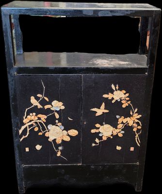 une armoire noire décorée de fleurs et d'oiseaux peints