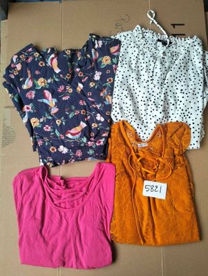 three tops are on a cardboard box with a price tag