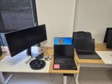 a desk with two laptops and a monitor on it