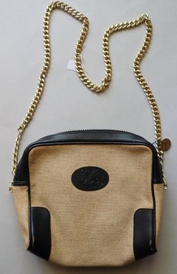 a close up of a purse on a table with a chain around it
