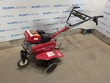 a red lawn mower sitting in front of a blue and white wall