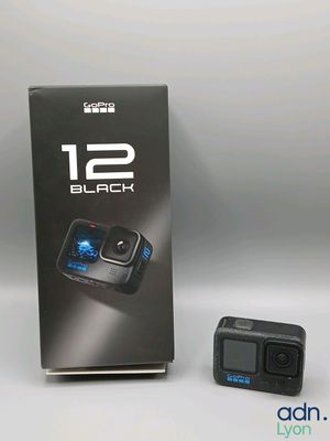 an image of a black gopro camera next to a box of its packaging