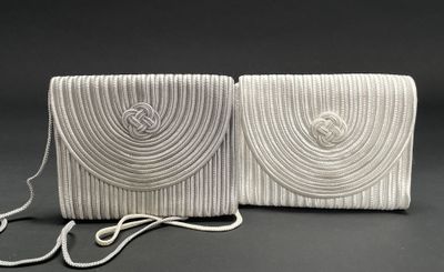 two white purses on a black background with a rope