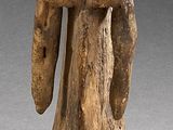 statue d'un homme coiffé d'un chapeau, posée sur un socle en bois