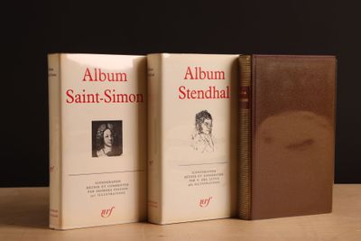 deux livres posés sur une table, sur fond noir, et un livre marron