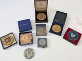 de nombreuses pièces de monnaie de toutes sortes dans une boîte posée sur une table
