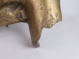 a gold statue of a cow on a white surface