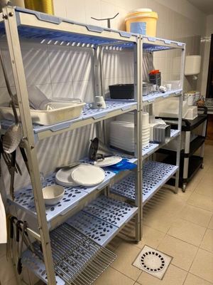 une étagère en métal sur laquelle sont posés des plats, dans une cuisine
