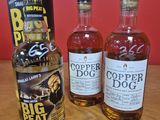 trois bouteilles de « Copper Dog » et un carton de bière posés sur une table