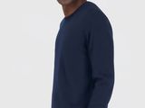 the man is wearing a blue sweater and black sweatpants