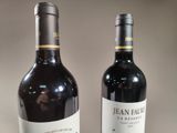 two bottles of wine sitting next to each other on a table