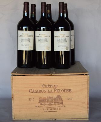 four bottles of red wine in a wooden box on a table