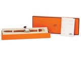 an orange box with a watch inside of it on a white surface