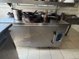 a large stainless steel kitchen with many pots and pans on the counter