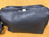 une trousse de toilette en cuir noir sur fond jaune