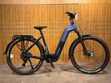 un vélo électrique bleu garé devant un mur en bois