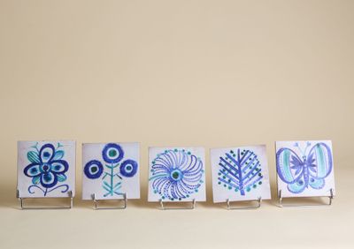 quatre petites cartes ornées de motifs bleus et verts, posées sur une table
