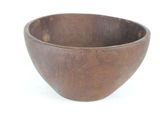 a wooden bowl that is sitting on a white surface