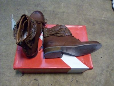 une paire de chaussures marron posée sur une boîte par terre