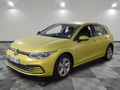 a yellow volkswagen golf is parked on a checkered floor
