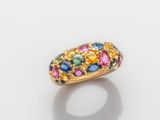 gros plan d'une bague en or avec des pierres multicolores