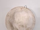 a white bowl on a white surface with a hook