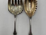 deux cuillères et une fourchette en argent sur une surface blanche