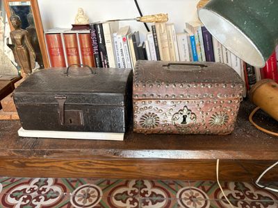 two trunks sitting on top of a table with a lamp