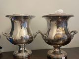 two silver vases sitting on a wooden table