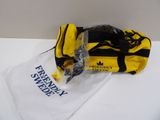 un sac jaune et noir posé sur une table blanche