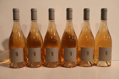 six bottles of wine are lined up in a row on a table