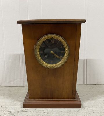 an image of a wooden clock with a black face and gold trim