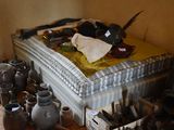 a bed with a mattress and many pots on the floor