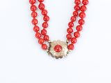 necklace made of red coral beads with a gold flower pendant