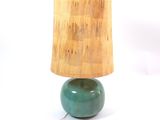 a green lamp with a wooden shade on top of it